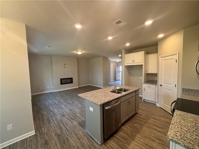 kitchen featuring sink, dishwasher, a kitchen island with sink, light stone counters, and white cabinets