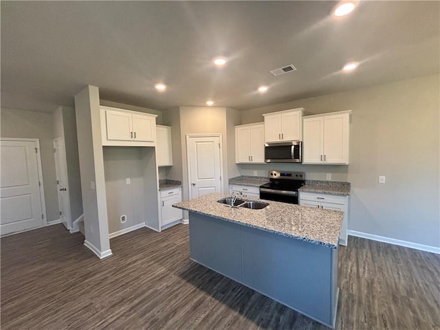 kitchen featuring sink, dark wood-type flooring, appliances with stainless steel finishes, white cabinetry, and a center island with sink