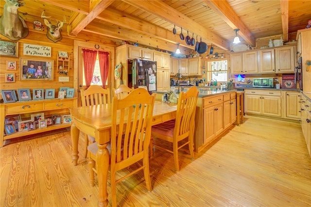 dining space featuring light hardwood / wood-style flooring, beamed ceiling, and wooden ceiling