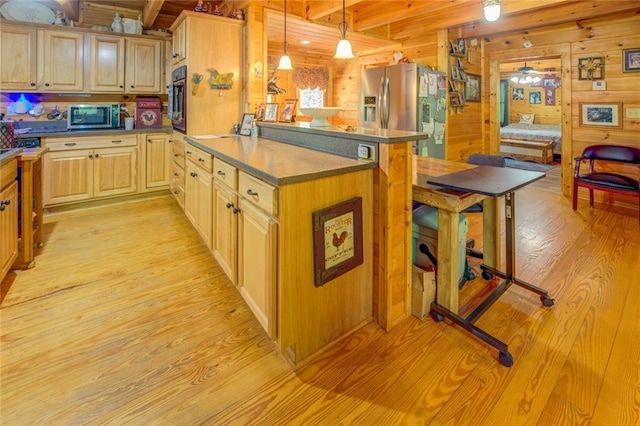 kitchen featuring beam ceiling, wooden walls, hanging light fixtures, and stainless steel appliances