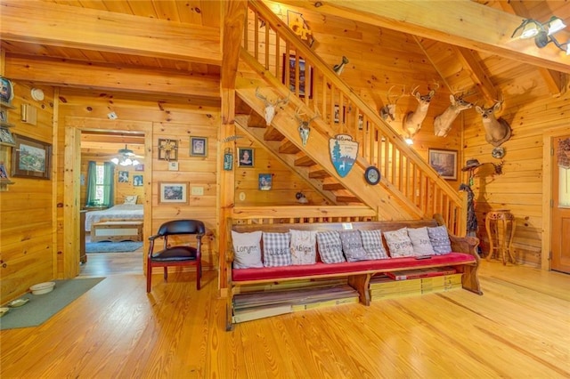 living room with hardwood / wood-style floors, vaulted ceiling with beams, wood walls, and wood ceiling