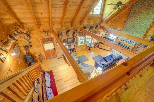 living room with a wealth of natural light, ceiling fan, wooden ceiling, wood walls, and wood-type flooring