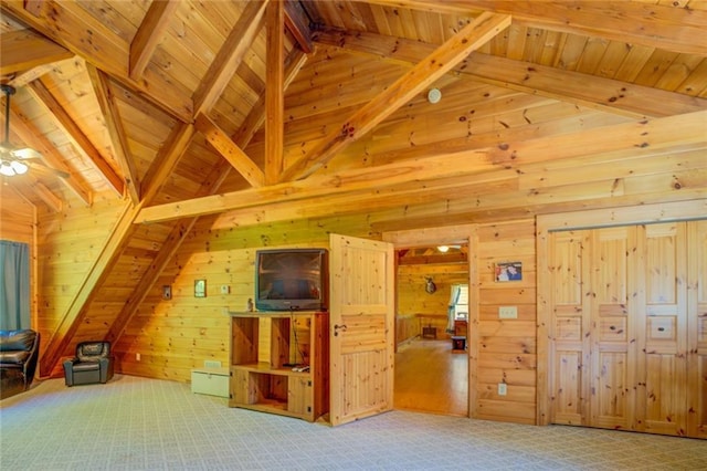 additional living space featuring ceiling fan, beamed ceiling, wood walls, carpet floors, and wood ceiling