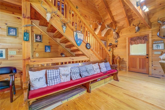 interior space featuring lofted ceiling with beams, hardwood / wood-style flooring, wooden ceiling, and wood walls