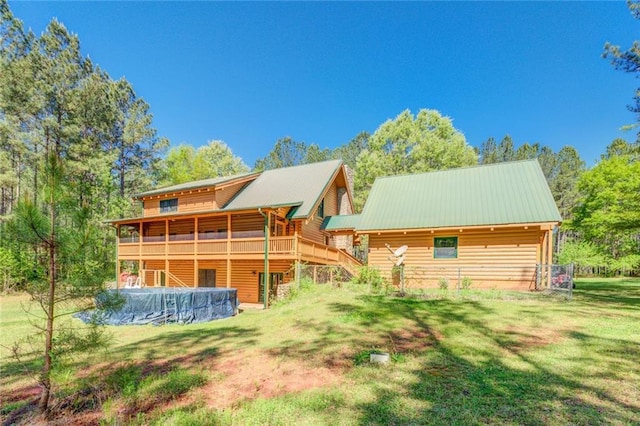 back of property with a yard and a wooden deck