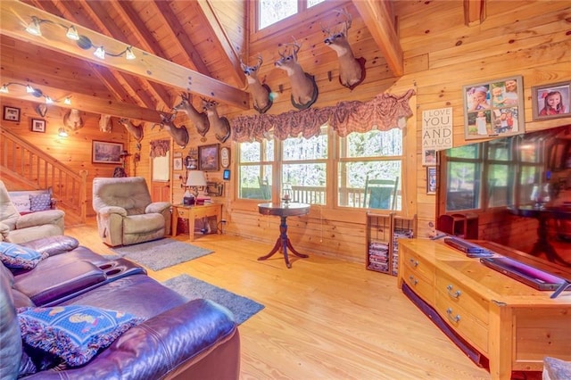 living room featuring lofted ceiling with beams, wooden walls, wooden ceiling, and light wood-type flooring