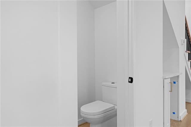 bathroom with hardwood / wood-style floors and toilet