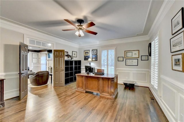 office space featuring light wood-type flooring, a healthy amount of sunlight, and crown molding