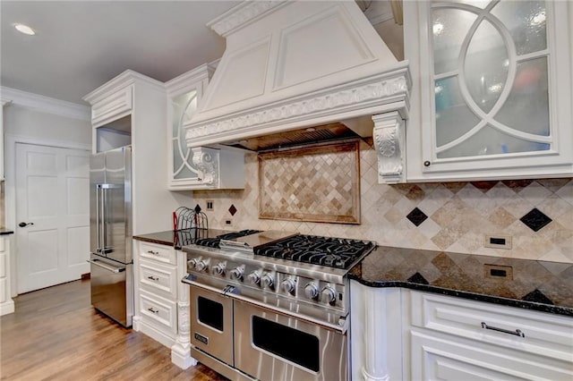 kitchen featuring decorative light fixtures, a large island with sink, a kitchen bar, and built in appliances