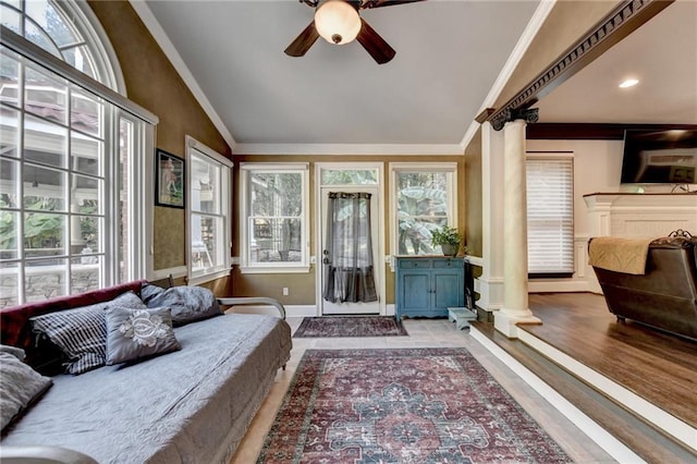 living room with crown molding, ceiling fan, ornate columns, light hardwood / wood-style floors, and lofted ceiling