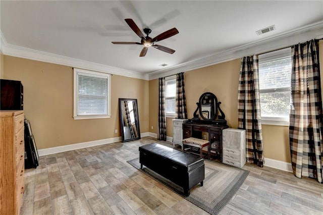 bedroom featuring ceiling fan, a tray ceiling, crown molding, and light wood-type flooring