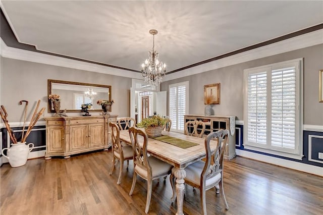 dining room with a chandelier, crown molding, and dark hardwood / wood-style floors