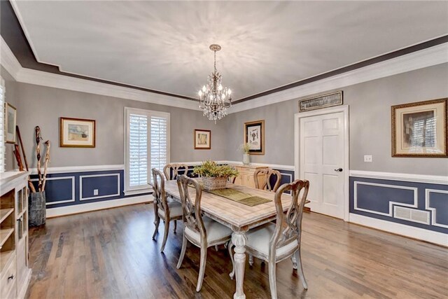 dining space featuring a chandelier, light hardwood / wood-style flooring, and ornamental molding