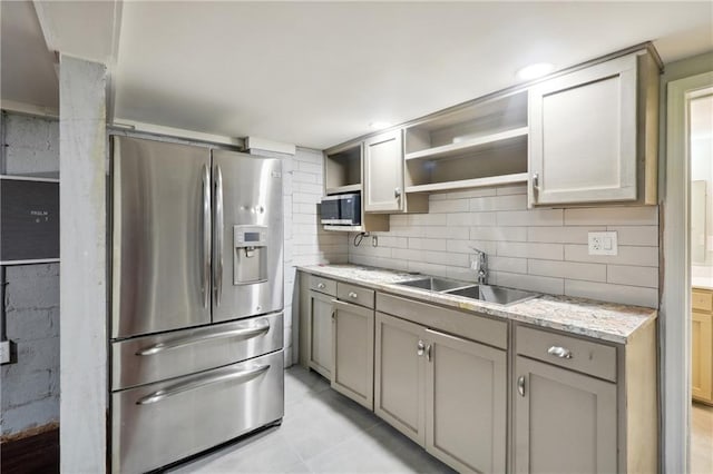 1192 Eastridge Rd SW, Atlanta, GA 30311 - kitchen featuring sink, appliances with stainless steel finishes, light stone countertops, light tile patterned flooring, and decorative backsplash