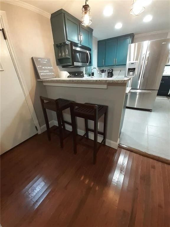1192 Eastridge Rd SW, Atlanta, GA 30311 - kitchen featuring a breakfast bar area, blue cabinetry, appliances with stainless steel finishes, dark hardwood / wood-style floors, and kitchen peninsula