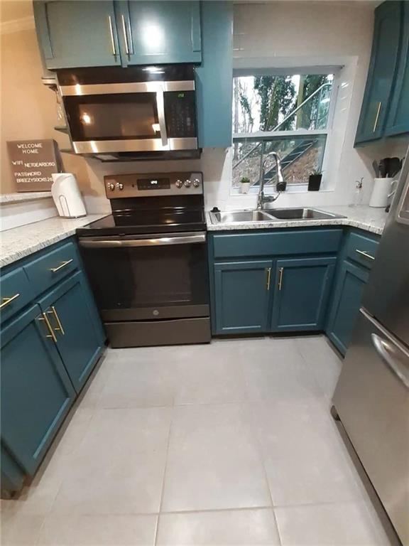 1192 Eastridge Rd SW, Atlanta, GA 30311 - kitchen featuring sink, blue cabinetry, light tile patterned flooring, and appliances with stainless steel finishes