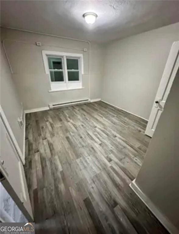 430 E 23rd St, Anniston, AL 36207 - unfurnished bedroom featuring a baseboard radiator, wood finished floors, and baseboards