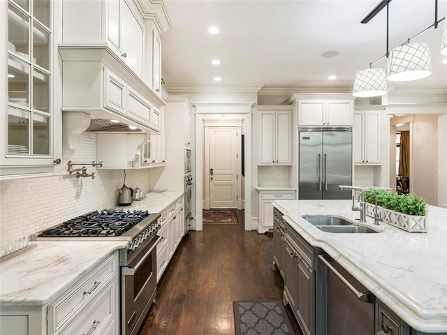 kitchen featuring hanging light fixtures, dark wood-type flooring, premium appliances, sink, and white cabinetry