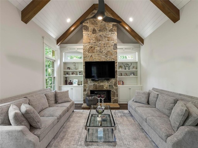 living room with built in features, beamed ceiling, a fireplace, high vaulted ceiling, and hardwood / wood-style flooring