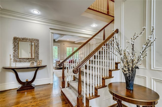 stairs with crown molding and dark hardwood / wood-style flooring