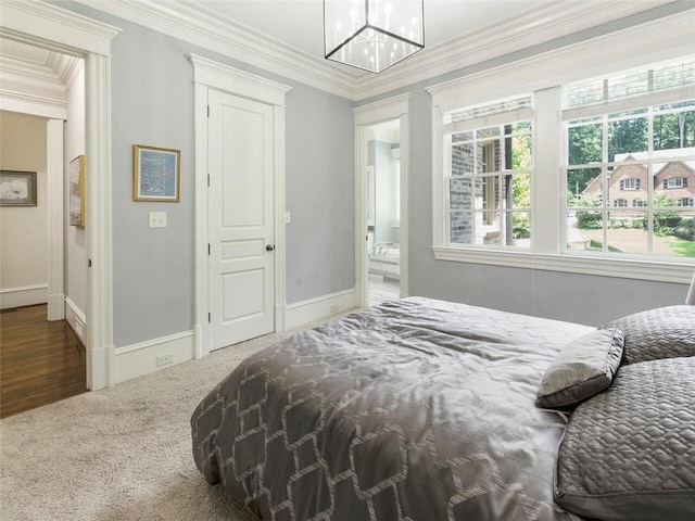 bedroom featuring an inviting chandelier, dark colored carpet, and crown molding