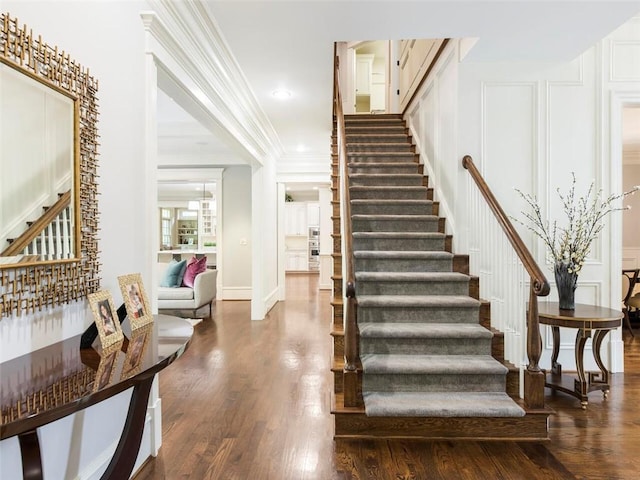 stairway featuring dark hardwood / wood-style flooring and crown molding