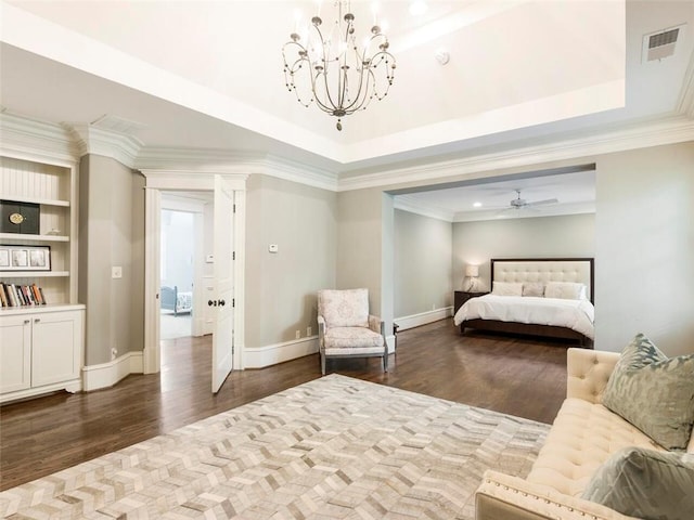 bedroom featuring a raised ceiling, ornamental molding, wood-type flooring, and a notable chandelier