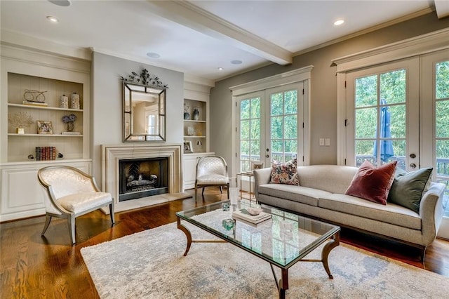 living room with dark wood-type flooring, french doors, beam ceiling, and ornamental molding