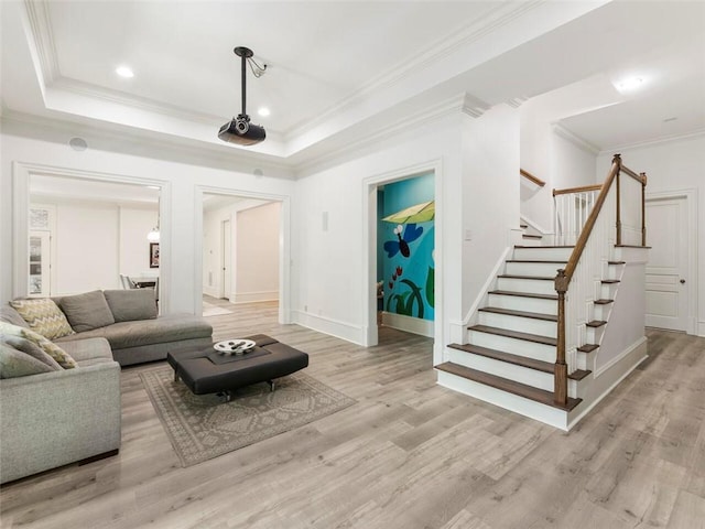 living room with a raised ceiling and light hardwood / wood-style floors