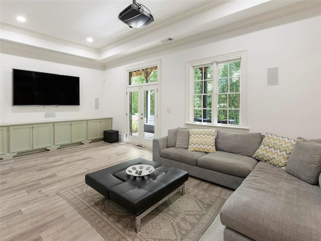 living room with french doors, crown molding, light hardwood / wood-style floors, and a raised ceiling