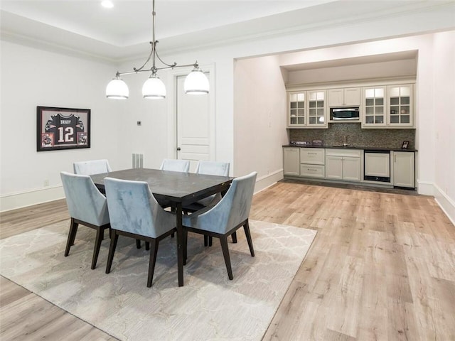 dining area featuring an inviting chandelier, light hardwood / wood-style flooring, and sink