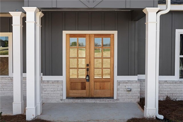 view of exterior entry with french doors and board and batten siding