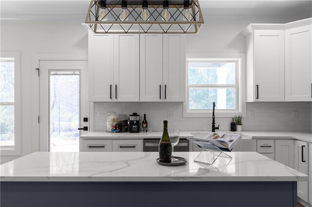 kitchen with white cabinetry, dishwashing machine, and backsplash