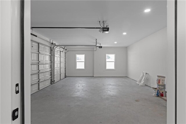 garage with recessed lighting, a garage door opener, and baseboards