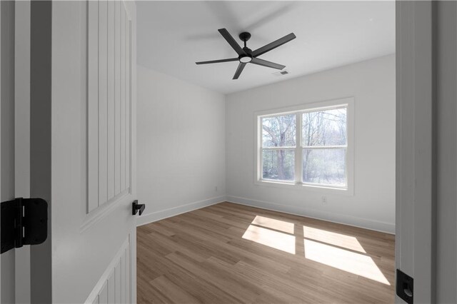 spare room featuring visible vents, baseboards, and light wood finished floors