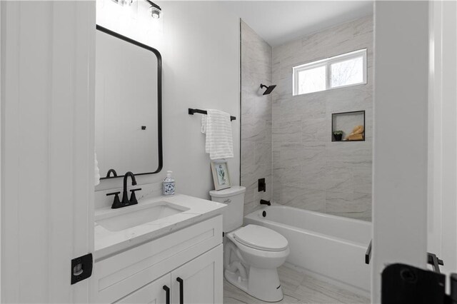 full bathroom with washtub / shower combination, toilet, marble finish floor, and vanity
