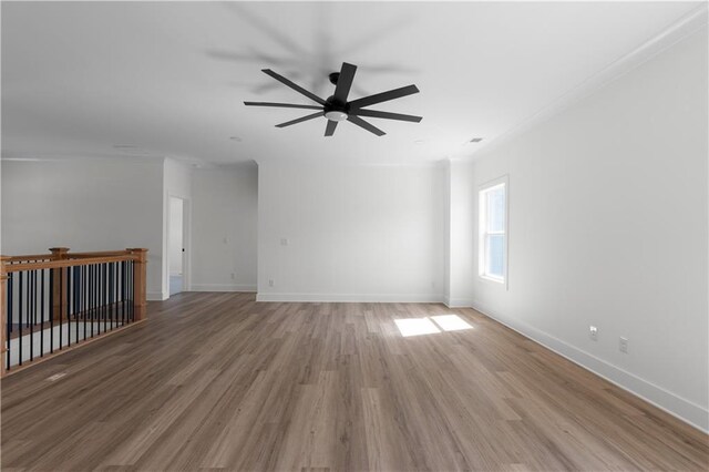 empty room featuring baseboards, ceiling fan, and light wood finished floors