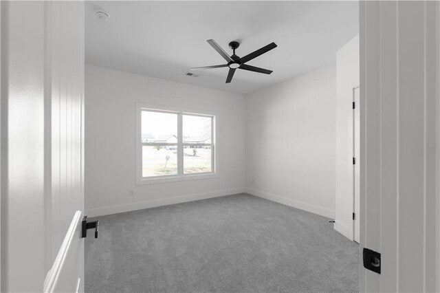 unfurnished room with visible vents, baseboards, carpet, and ceiling fan