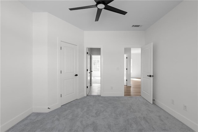 unfurnished bedroom featuring baseboards, visible vents, carpet floors, and ceiling fan