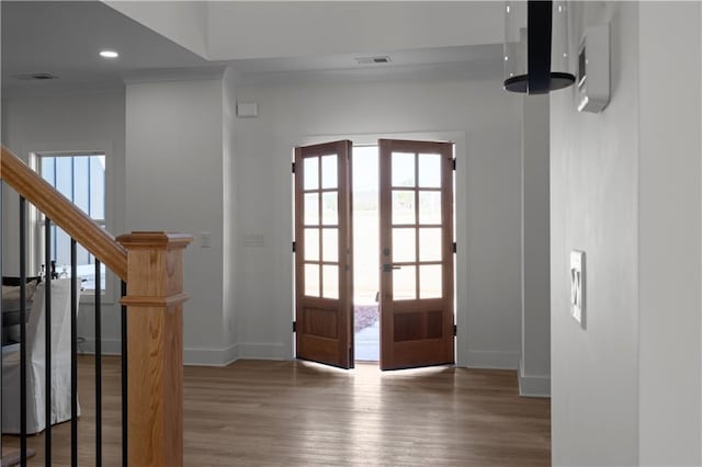 entrance foyer featuring visible vents, ornamental molding, wood finished floors, french doors, and baseboards