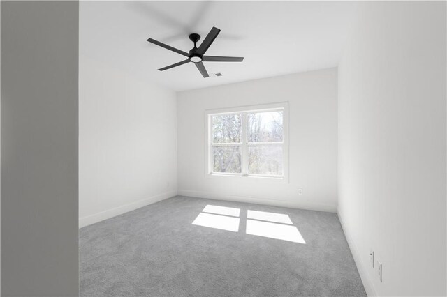 spare room featuring a ceiling fan, carpet, visible vents, and baseboards