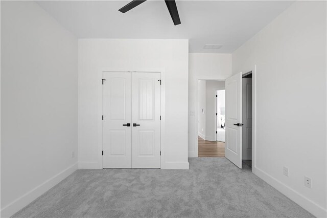unfurnished bedroom with a closet, baseboards, carpet, and a ceiling fan