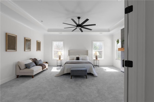bedroom featuring multiple windows, a raised ceiling, and carpet floors