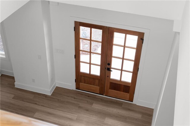 foyer with wood finished floors, french doors, and baseboards