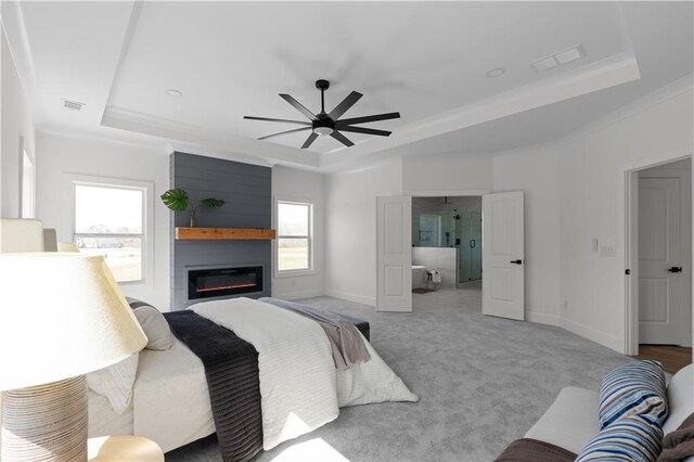 bedroom with visible vents, a tray ceiling, carpet, crown molding, and baseboards