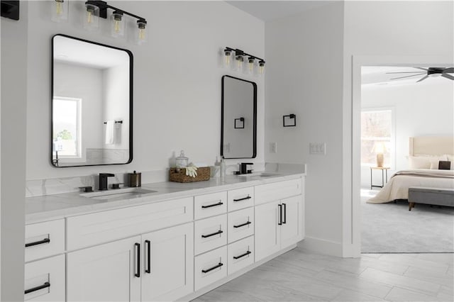 full bath with double vanity, ensuite bathroom, ceiling fan, and a sink