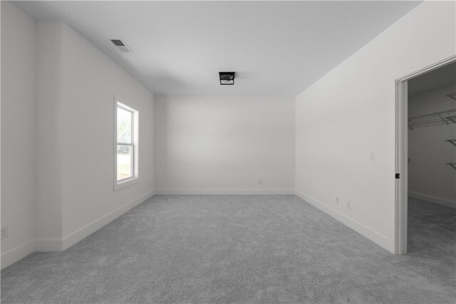 empty room featuring visible vents, baseboards, and carpet