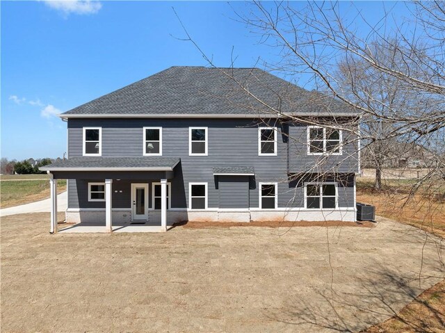 back of house with a patio, cooling unit, a lawn, and a shingled roof