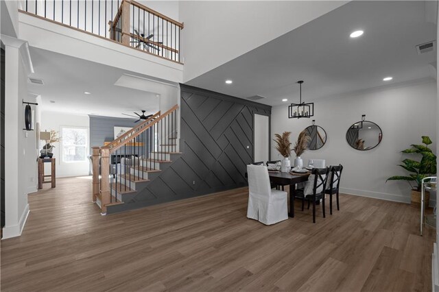 dining space with visible vents, wood finished floors, recessed lighting, ceiling fan, and stairs