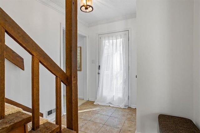 foyer entrance featuring light tile patterned floors and ornamental molding